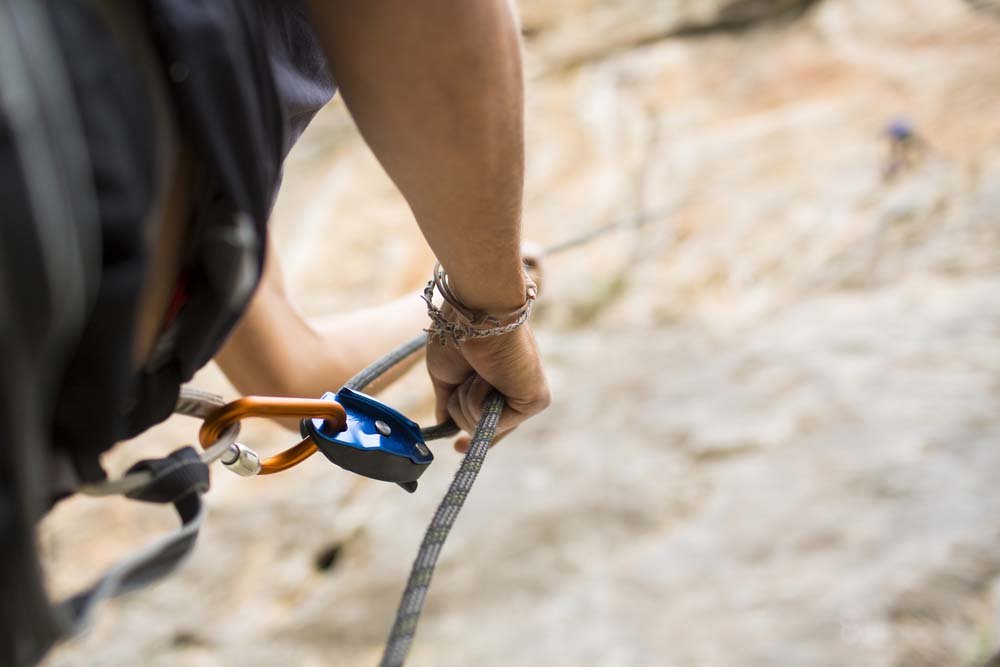 man performing a belay outdoors