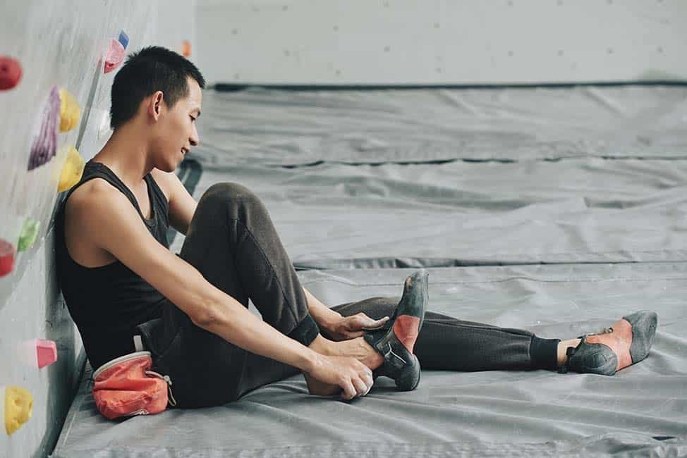 climber putting on slipper climbing shoes