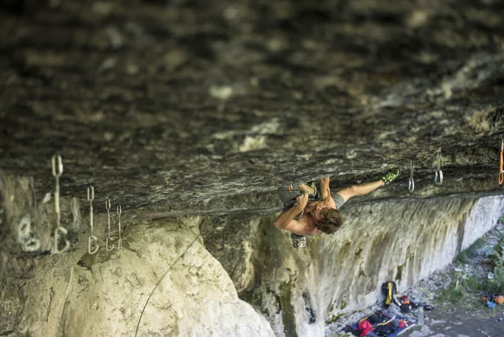 yonug man pulling through roof using kneebar to clip