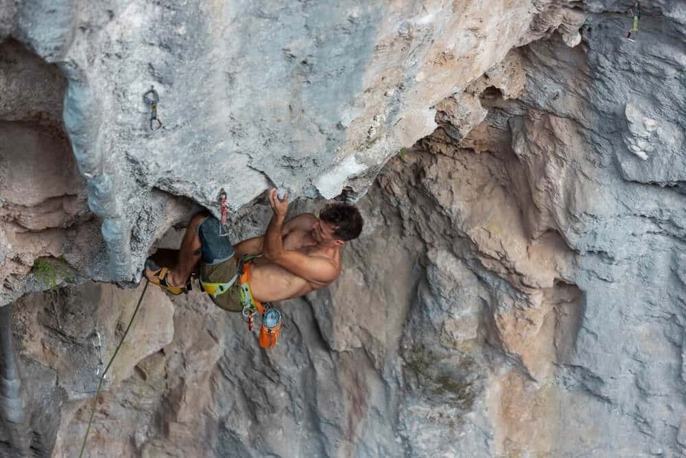 man using a kneebar when climbing