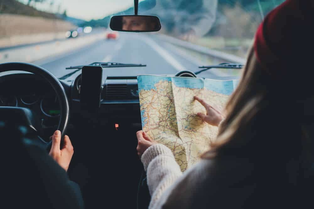 couple driving with map