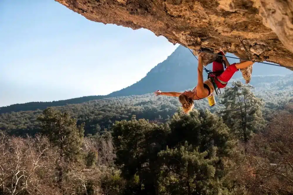 female climber resting with kneebar in cave