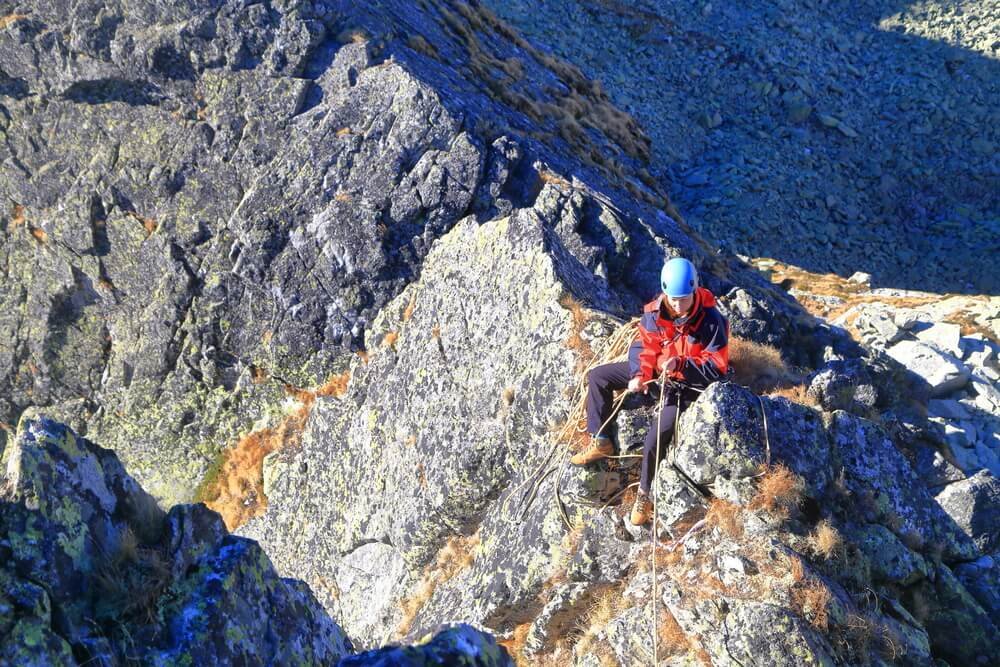 man belaying on arete