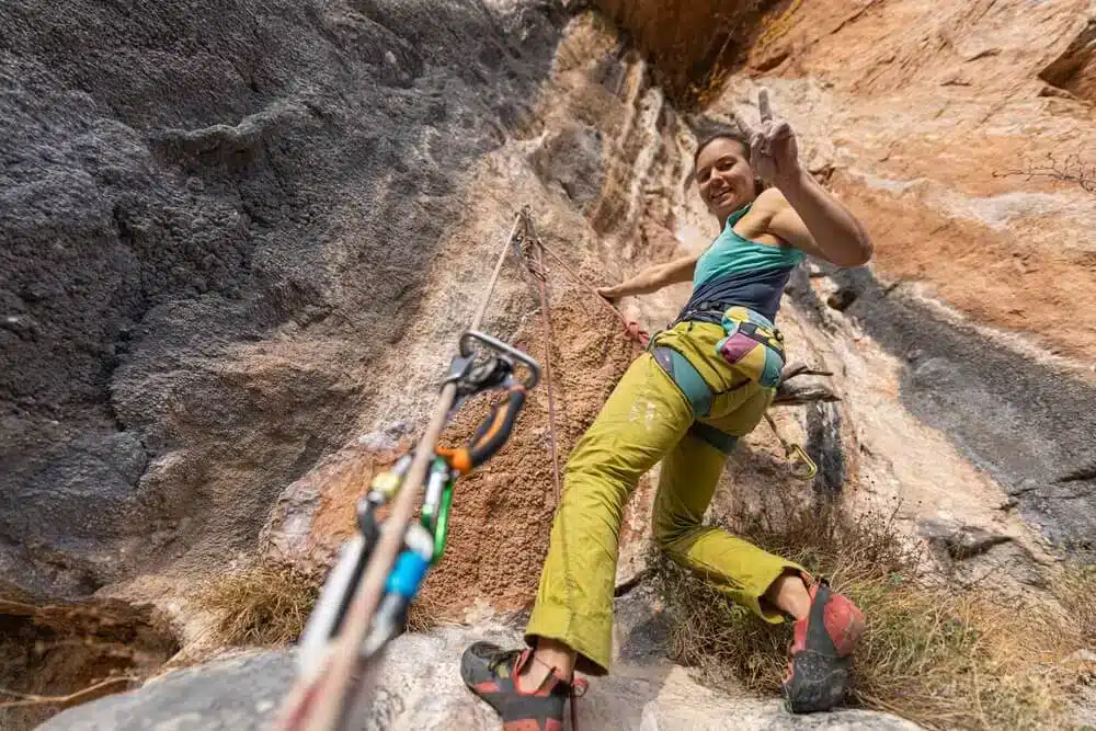 young woman at top of sport climb