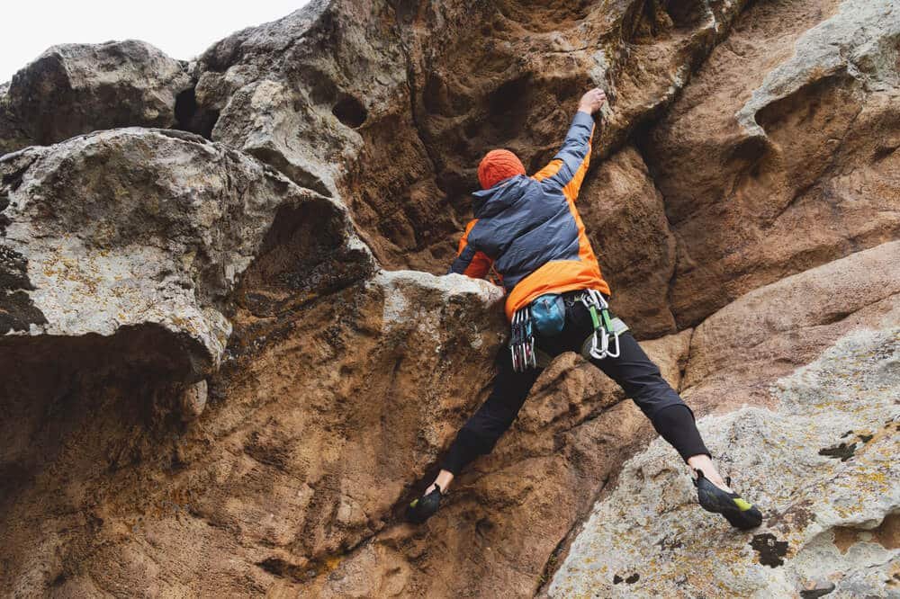 climber with beanie climbs steep roof