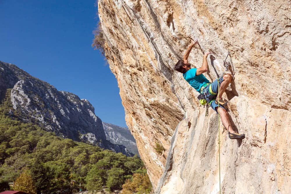 man climbing outdoors using rear flag