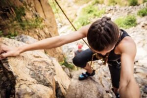 young woman climbing up outdoors