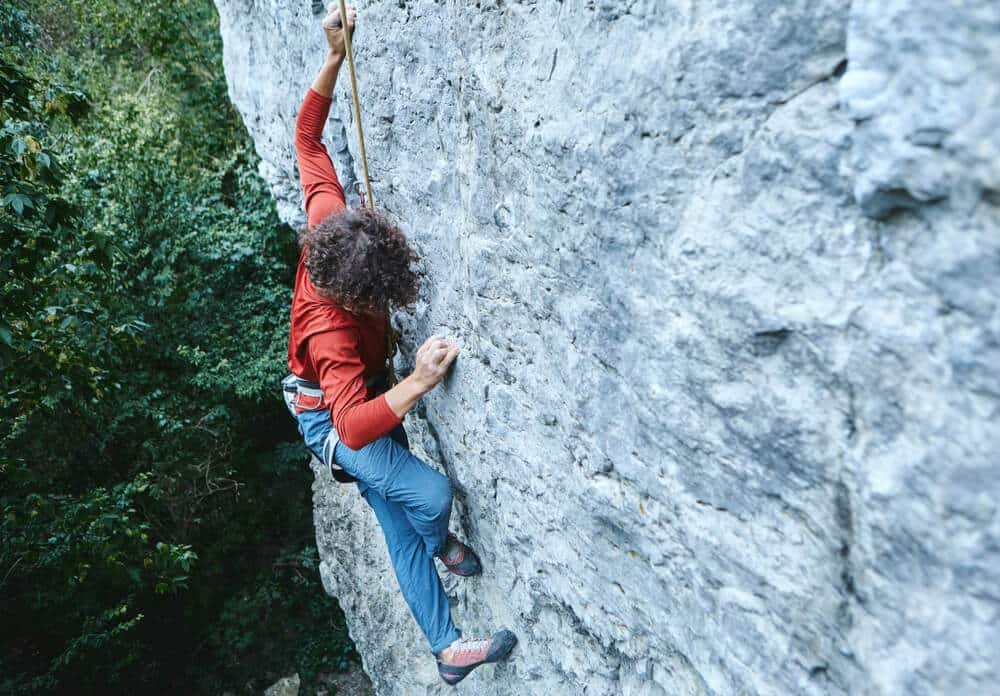 man backstepping when top roping on climb outdoors