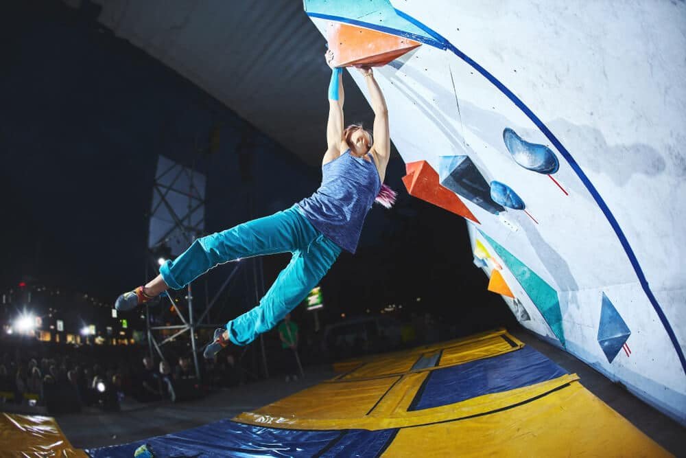 woman catching hold after dyno when bouldering