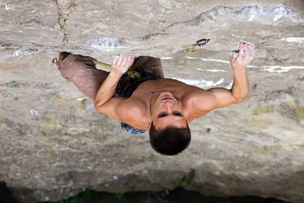 young man redpointing climb