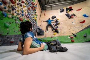 climber lying down resting watching other boulderer