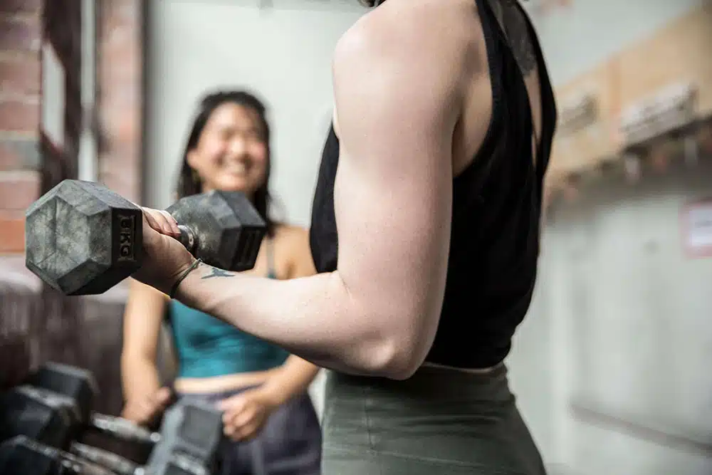 female climber holding dumbbell for strength training