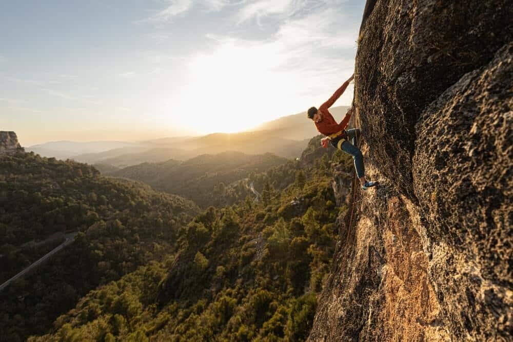 climber looking down route at sunset